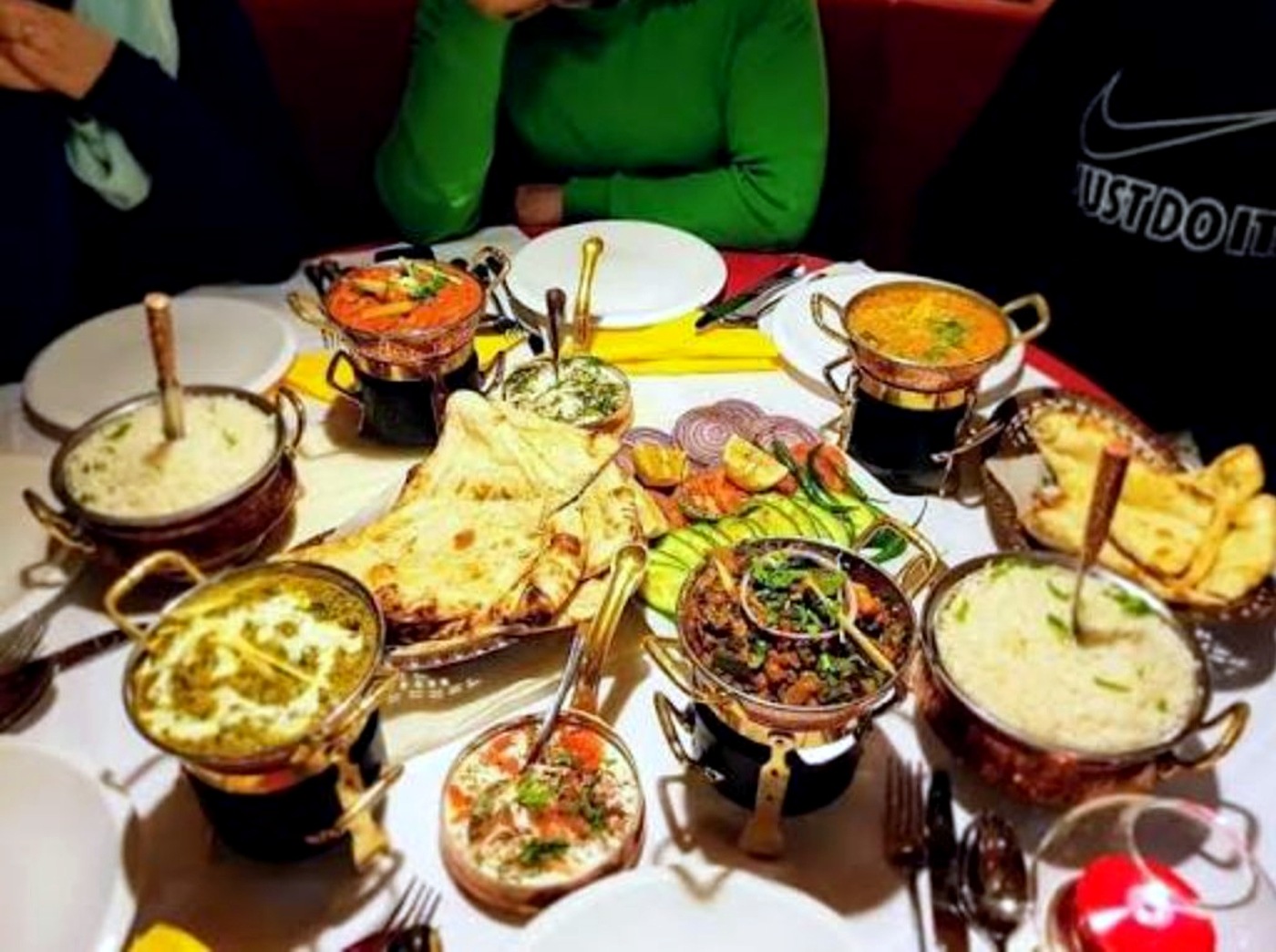 Ganesha — gedeckte Tafel mit Curries, Naan und Reis