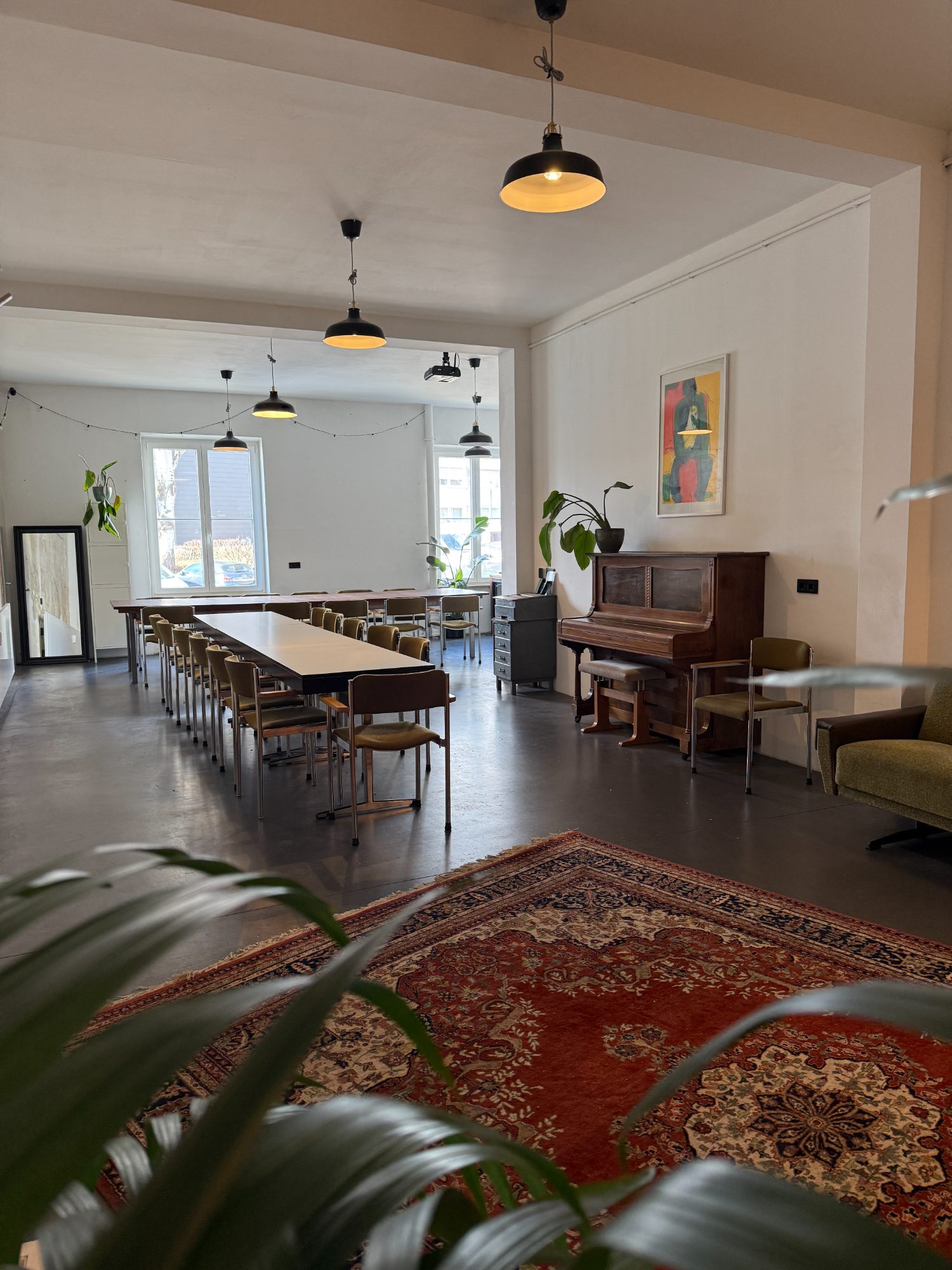 Wohnzimmer mit Holztafel, Klavier und Teppich