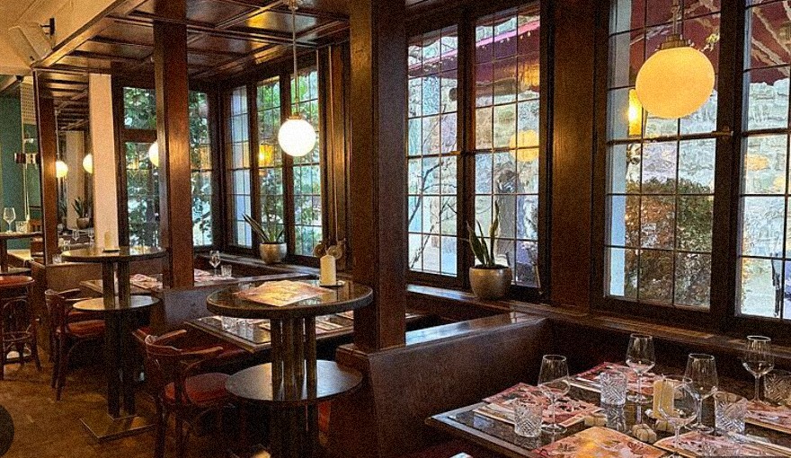 Roia — warmes, holzgetäfeltes Restaurant-Interieur mit gedeckten Tischen